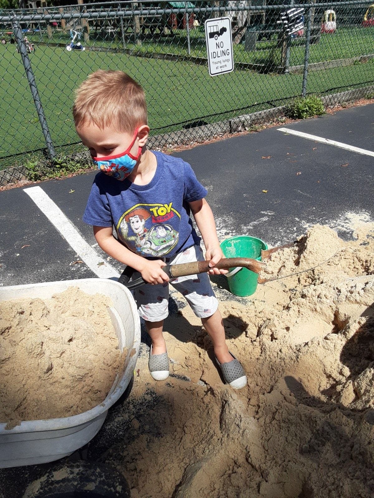 A child very involved in shoveling sand during the camp at Paoli.